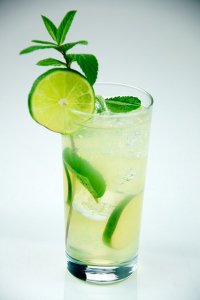 A mojito is packed with mint leaves and served in a long glass.